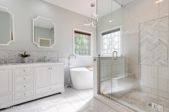 bathroom with a freestanding tub, a shower stall, tile patterned flooring, and vanity