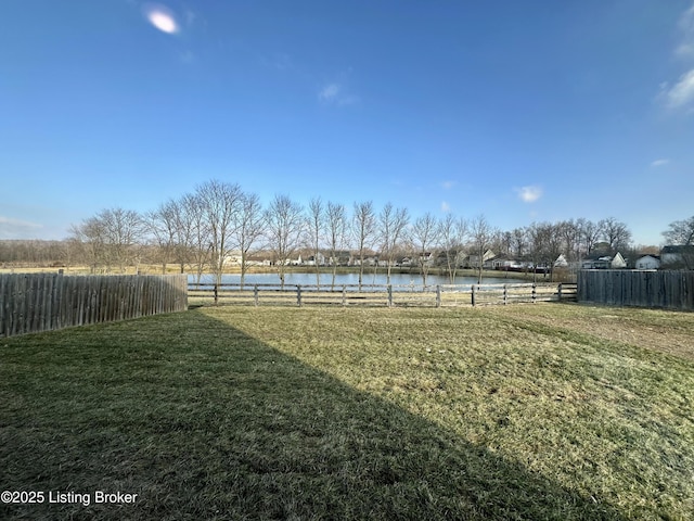 view of yard with a water view and fence