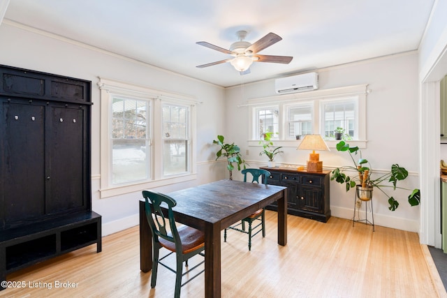 dining room with crown molding, ceiling fan, light wood-type flooring, a wall mounted air conditioner, and baseboards