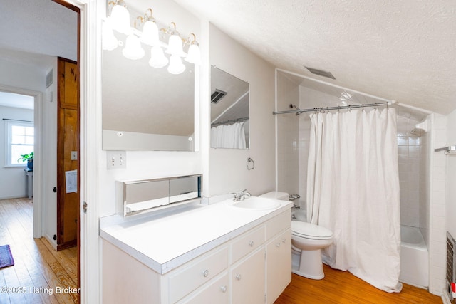 bathroom featuring a textured ceiling, lofted ceiling, toilet, wood finished floors, and shower / bath combination with curtain