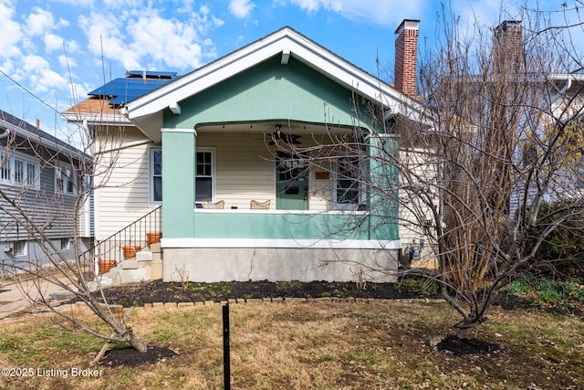 view of front of home featuring roof mounted solar panels and a chimney