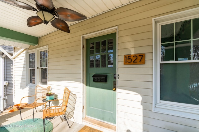 view of exterior entry featuring a porch and ceiling fan