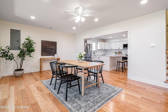 dining space with recessed lighting, a ceiling fan, baseboards, light wood-type flooring, and electric panel