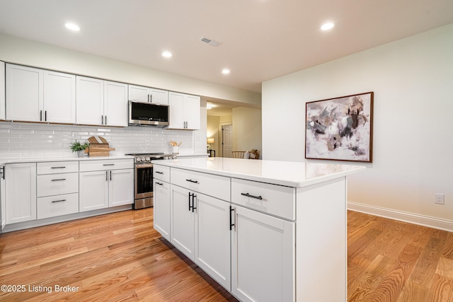 kitchen featuring light countertops, appliances with stainless steel finishes, visible vents, and light wood-style floors