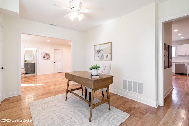 office space with baseboards, visible vents, and light wood-style floors