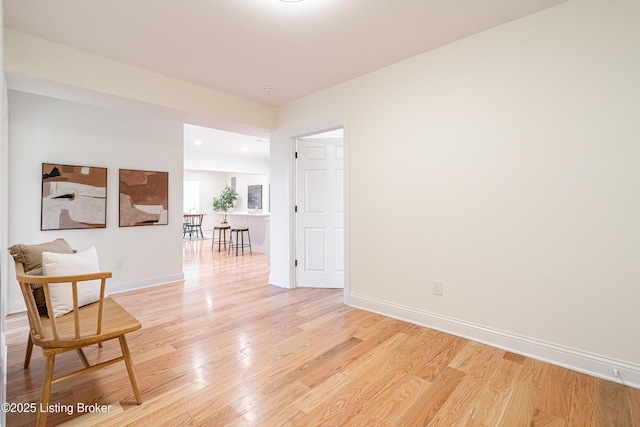 empty room featuring baseboards and light wood finished floors