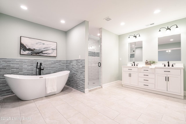 full bathroom with a soaking tub, visible vents, a sink, and a stall shower