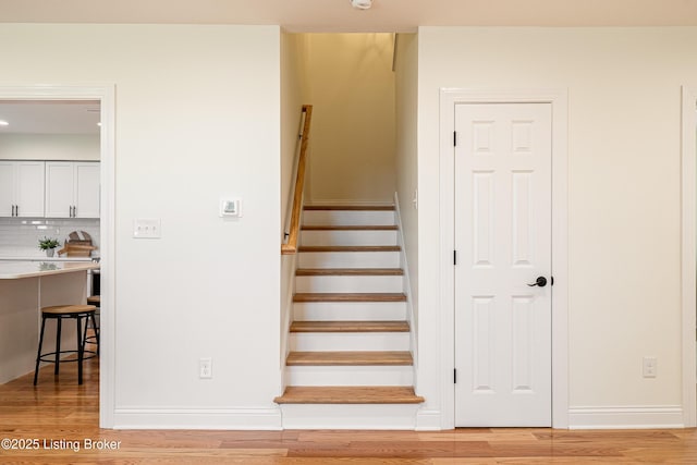 stairs featuring wood finished floors and baseboards