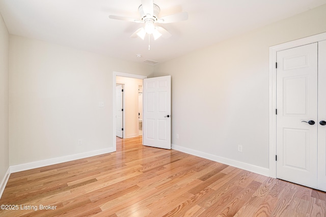 unfurnished bedroom featuring baseboards, ceiling fan, visible vents, and light wood-style floors