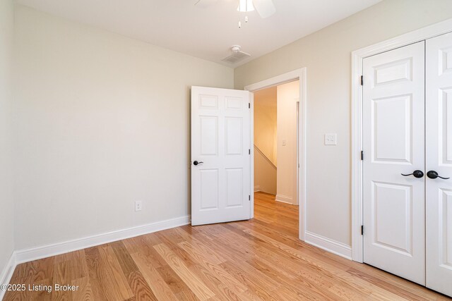 unfurnished bedroom with light wood finished floors, a ceiling fan, baseboards, and a closet