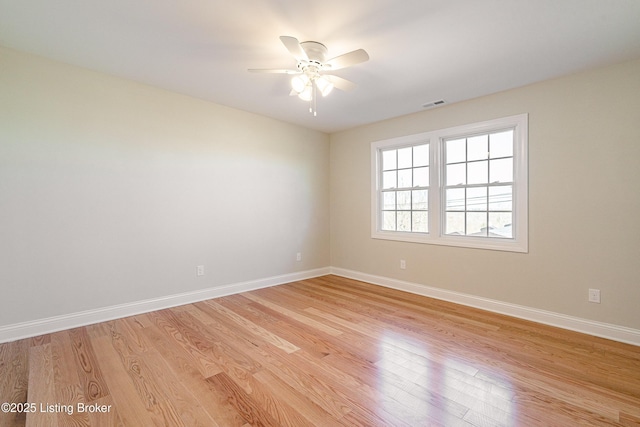 unfurnished room with light wood-type flooring, visible vents, and baseboards