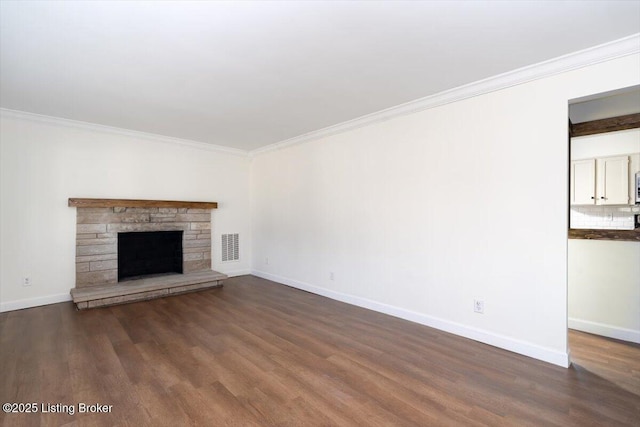 unfurnished living room featuring baseboards, dark wood finished floors, and crown molding