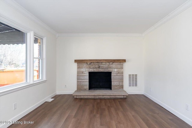 unfurnished living room featuring baseboards, wood finished floors, visible vents, and crown molding