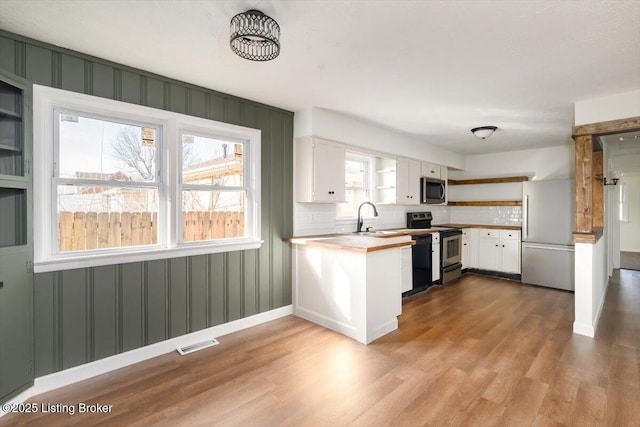 kitchen with appliances with stainless steel finishes, white cabinets, visible vents, and dark wood finished floors