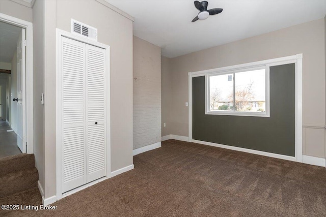 unfurnished bedroom with carpet floors, a closet, visible vents, and baseboards