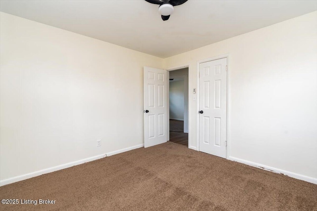 carpeted empty room featuring baseboards