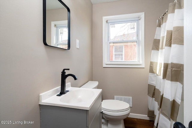 full bathroom featuring visible vents, toilet, vanity, wood finished floors, and baseboards