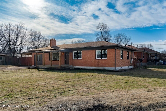 rear view of house featuring a yard, brick siding, and a chimney