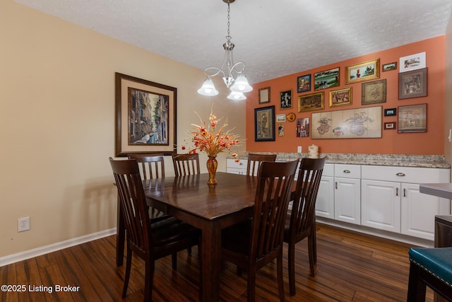 dining room featuring a textured ceiling, baseboards, and dark wood-type flooring