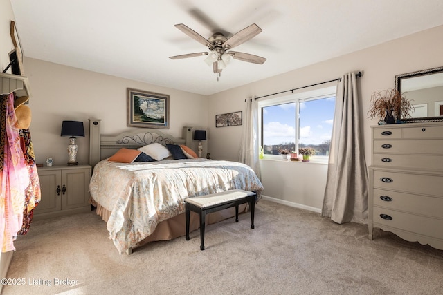 bedroom featuring ceiling fan, baseboards, and light colored carpet