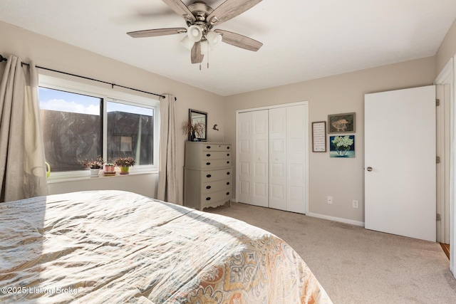 bedroom with light carpet, baseboards, a ceiling fan, and a closet