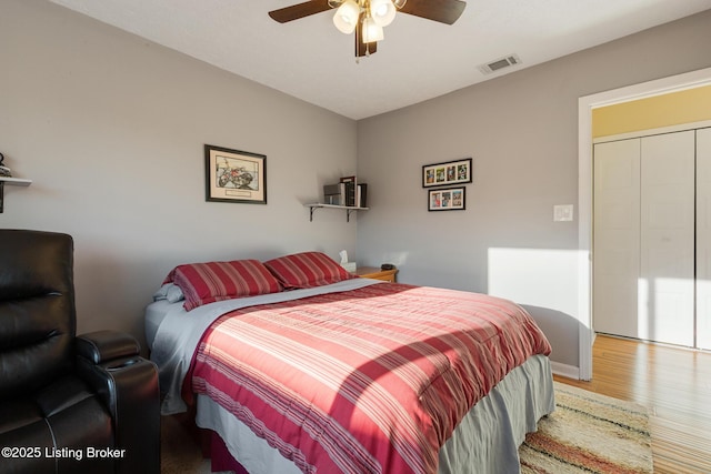 bedroom featuring visible vents, ceiling fan, and wood finished floors