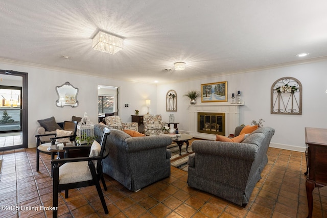 living room featuring baseboards, crown molding, and a glass covered fireplace