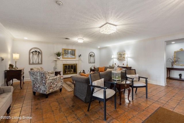 living area featuring baseboards, ornamental molding, a textured ceiling, and a glass covered fireplace