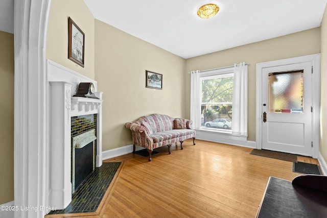 sitting room featuring a fireplace, wood finished floors, visible vents, and baseboards