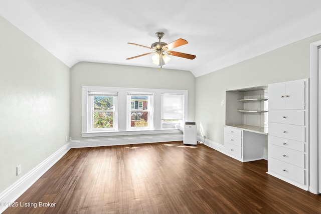 interior space with vaulted ceiling, ceiling fan, dark wood-style flooring, and baseboards