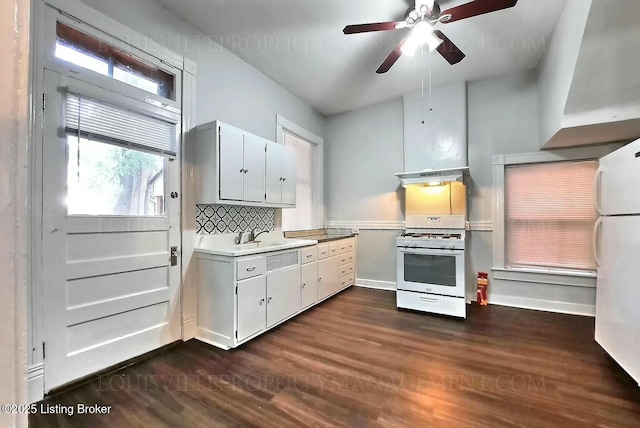 kitchen featuring white appliances, dark wood finished floors, light countertops, under cabinet range hood, and backsplash