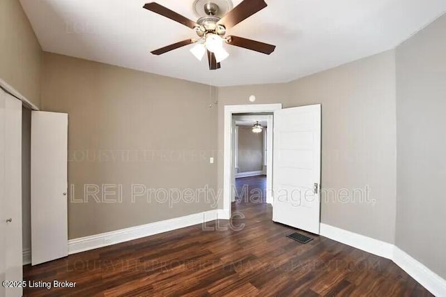 spare room with baseboards, visible vents, and wood finished floors