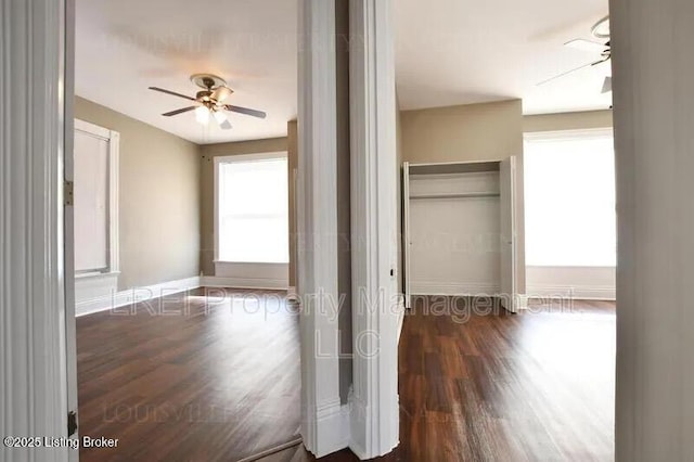 hallway with baseboards and wood finished floors