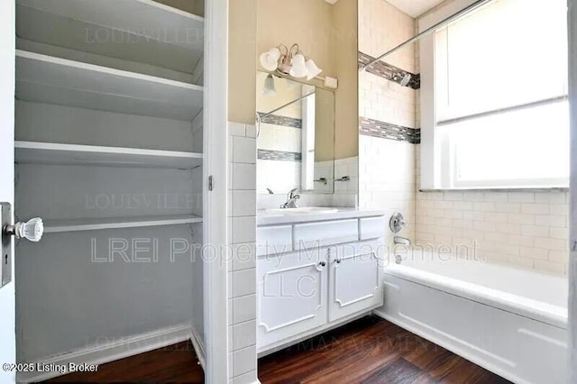 bathroom with shower / bath combination, wood finished floors, and vanity