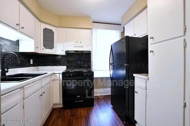 kitchen with under cabinet range hood, light countertops, black appliances, white cabinetry, and a sink