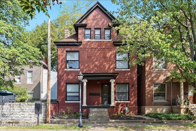 view of front of house with fence and brick siding