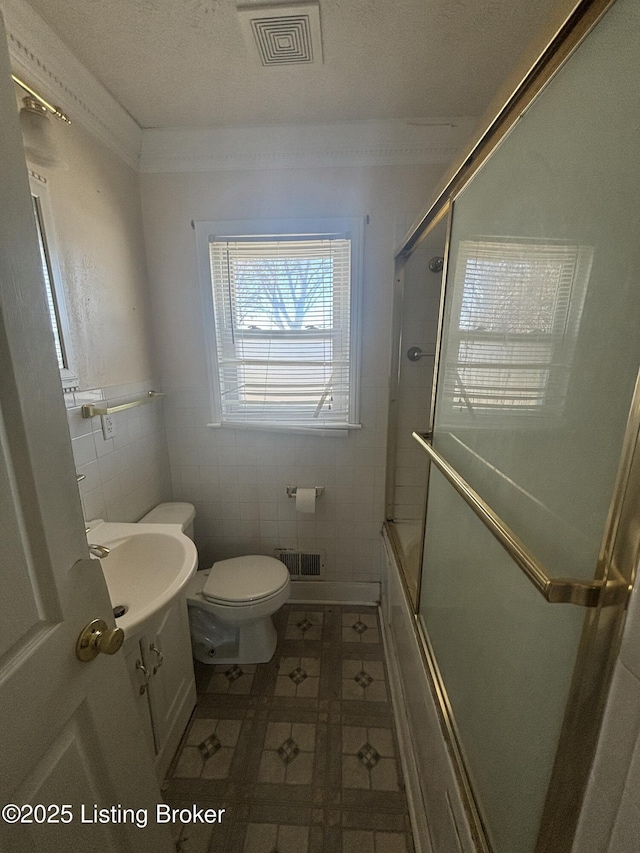 full bathroom featuring tile walls, visible vents, vanity, and toilet