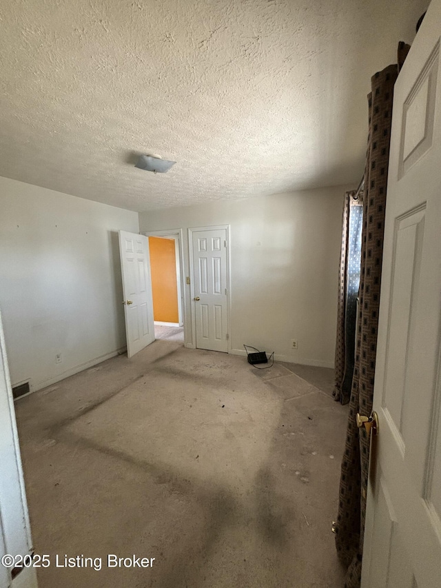 unfurnished bedroom featuring a textured ceiling and visible vents