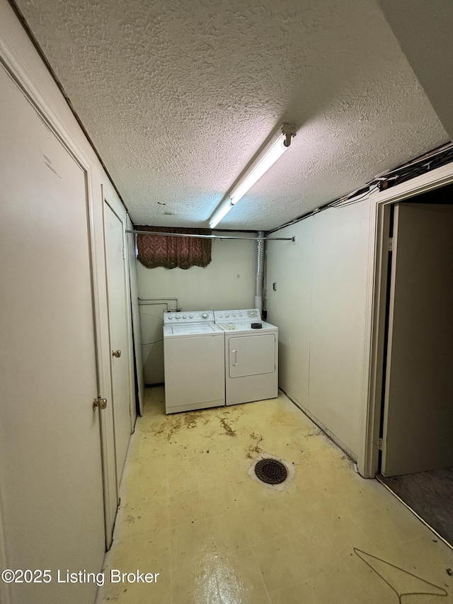 laundry area featuring laundry area, washer and clothes dryer, and a textured ceiling