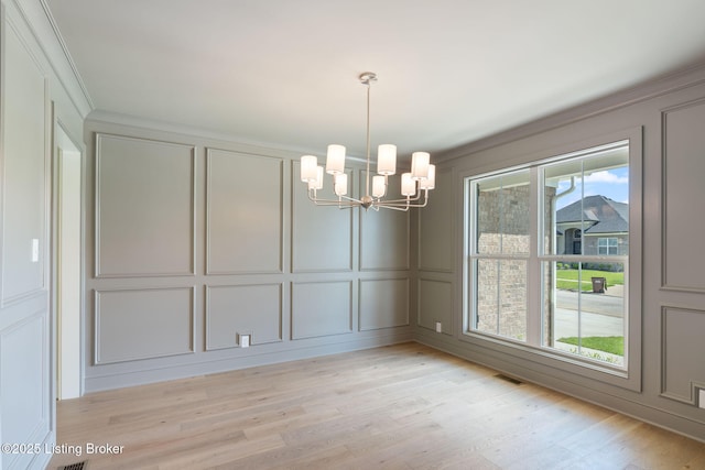 3314 Catalpa Farms Dr, Fisherville, KY 40023 - empty room with a decorative wall, a chandelier, ornamental molding, and light wood-style flooring