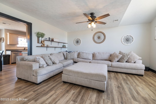 living room featuring a textured ceiling, wood finished floors, and visible vents