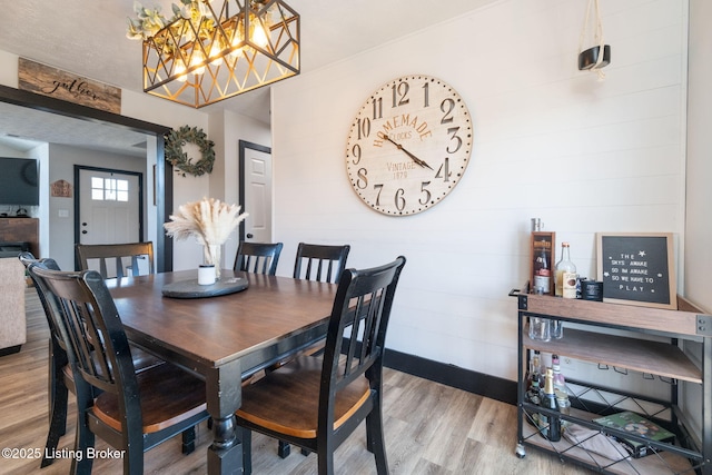 dining area featuring an inviting chandelier and wood finished floors