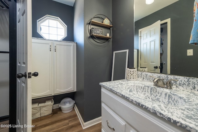 bathroom with wood finished floors, vanity, and baseboards