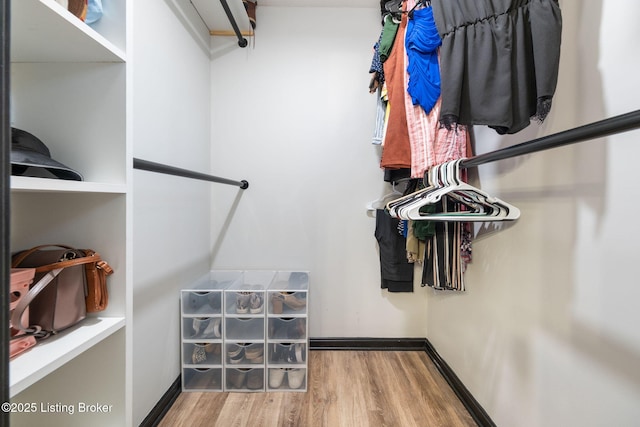 walk in closet with wood finished floors