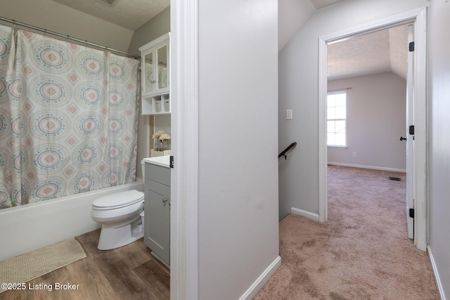 full bathroom featuring visible vents, toilet, shower / tub combo, vaulted ceiling, and vanity