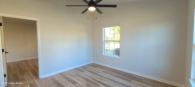 unfurnished room featuring wood finished floors, a ceiling fan, and baseboards