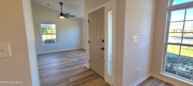 foyer featuring lofted ceiling, dark wood-style flooring, and baseboards