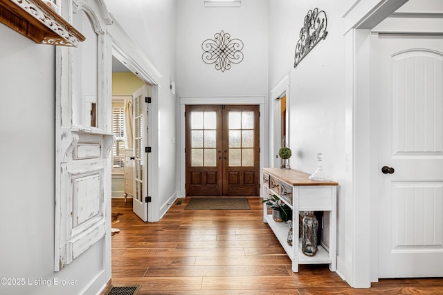 entrance foyer with french doors, hardwood / wood-style floors, and baseboards