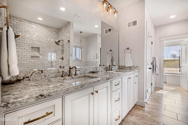 full bathroom featuring a stall shower, a sink, and visible vents