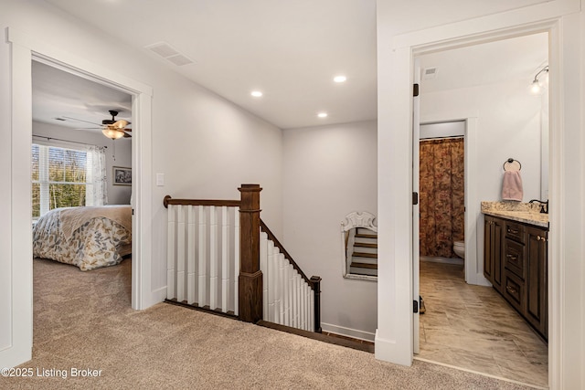 hall featuring recessed lighting, visible vents, light carpet, an upstairs landing, and baseboards